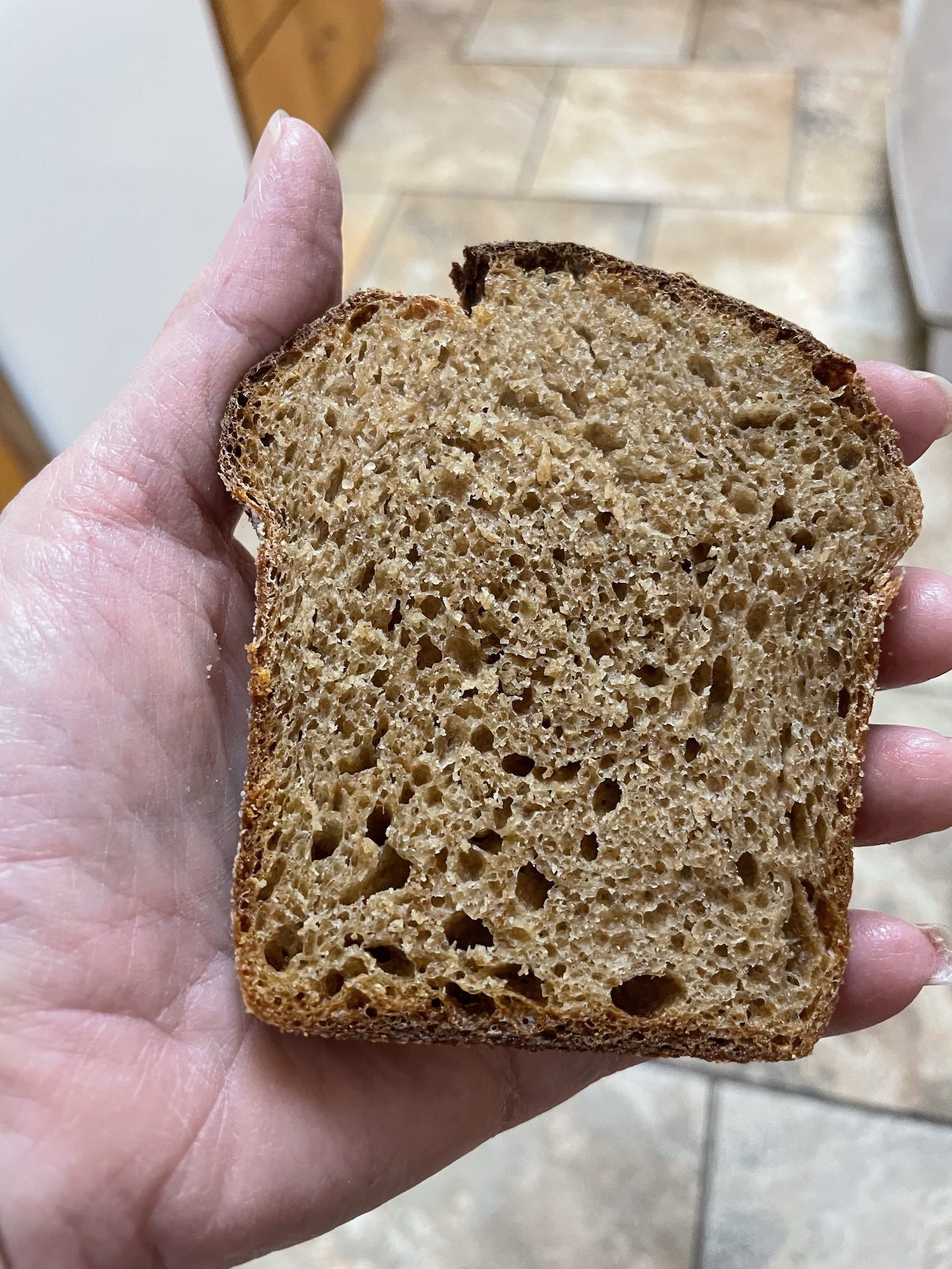 A slice of 100% whole wheat pear bread, made with fresh-milled flour, showing a lovely, light crumb structure.